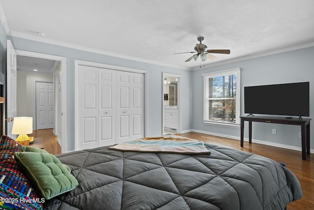 bedroom with baseboards, a closet, wood finished floors, and crown molding