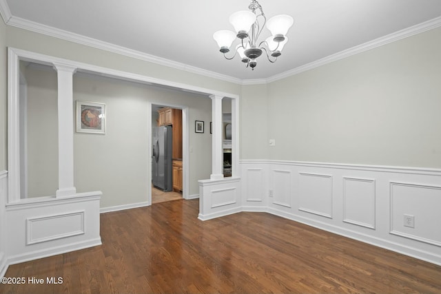 unfurnished room with ornate columns, ornamental molding, and dark wood finished floors