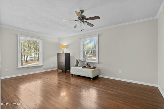 unfurnished room featuring a healthy amount of sunlight, baseboards, dark wood finished floors, and crown molding