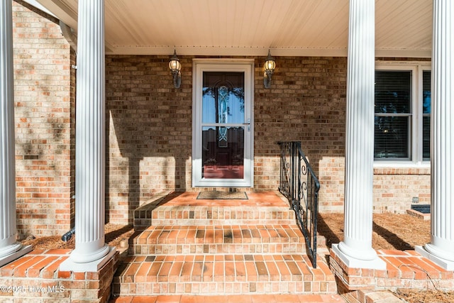 doorway to property featuring brick siding