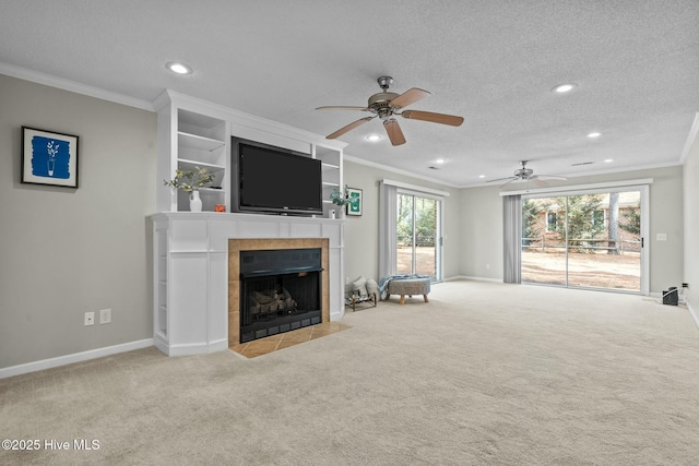 living area featuring light carpet, baseboards, a tile fireplace, a textured ceiling, and crown molding