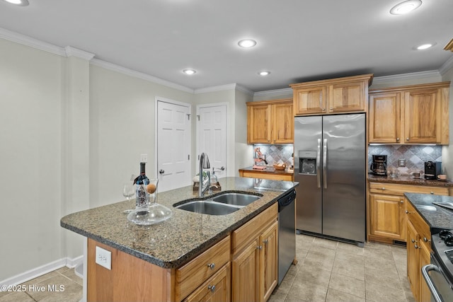 kitchen featuring an island with sink, appliances with stainless steel finishes, a sink, and ornamental molding