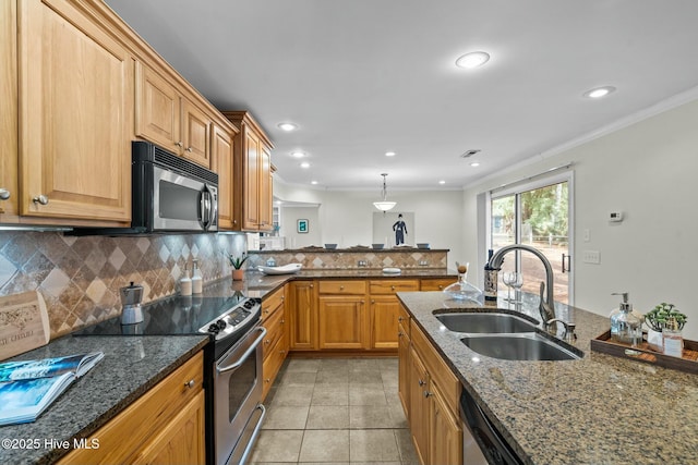 kitchen with decorative backsplash, dark stone counters, stainless steel appliances, crown molding, and a sink