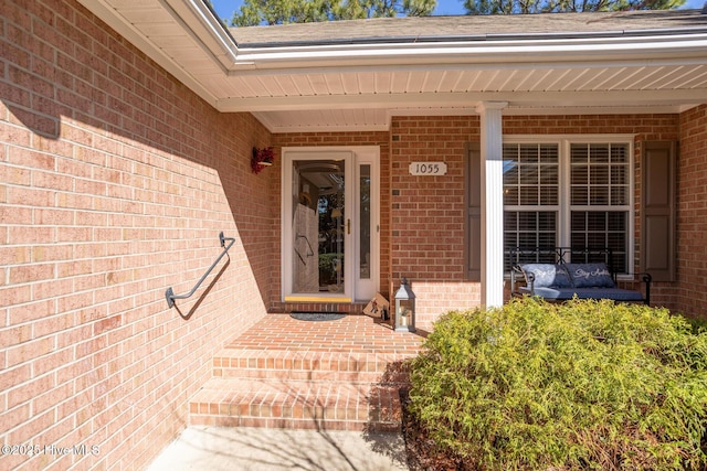 doorway to property featuring brick siding