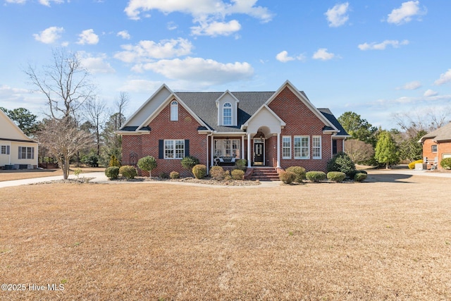 traditional-style house featuring a front lawn and brick siding