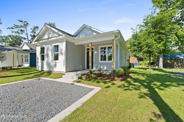 211 NE 78th St, Oak Island, NC 28465 - view of front of property with a porch, a front lawn, and board and batten siding