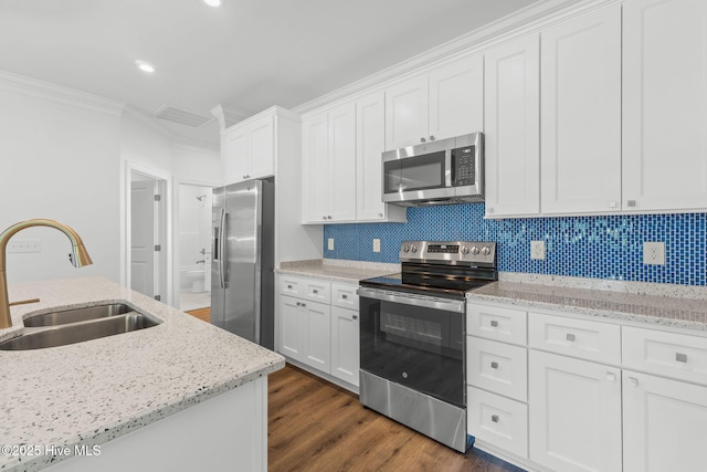 211 NE 78th St, Oak Island, NC 28465 - kitchen featuring appliances with stainless steel finishes, a sink, crown molding, white cabinets, and dark wood-type flooring