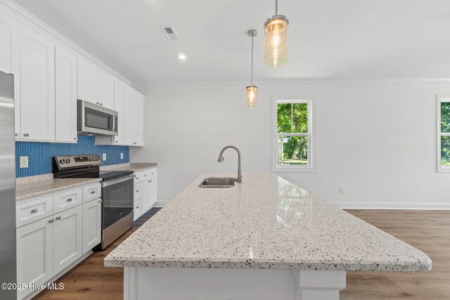 211 NE 78th St, Oak Island, NC 28465 - kitchen with stainless steel appliances, a sink, ornamental molding, white cabinets, and backsplash