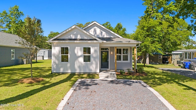 211 NE 78th St, Oak Island, NC 28465 - view of front of home featuring a front lawn, an outbuilding, and board and batten siding