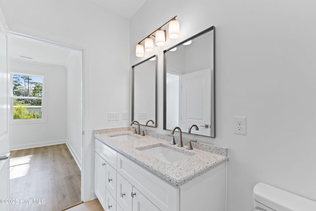 211 NE 78th St, Oak Island, NC 28465 - bathroom featuring double vanity, toilet, wood finished floors, and baseboards