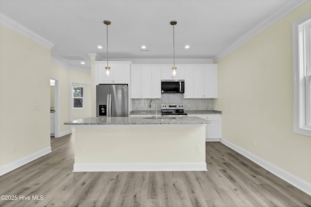 kitchen with white cabinetry, appliances with stainless steel finishes, decorative backsplash, an island with sink, and crown molding