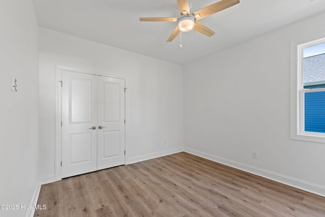 211 NE 78th St, Oak Island, NC 28465 - unfurnished bedroom featuring light wood-type flooring, baseboards, a closet, and ceiling fan