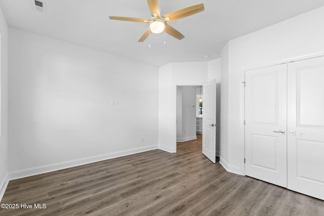 211 NE 78th St, Oak Island, NC 28465 - unfurnished bedroom with wood finished floors, baseboards, a closet, and ceiling fan