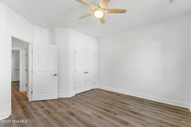 211 NE 78th St, Oak Island, NC 28465 - unfurnished bedroom featuring wood finished floors, baseboards, a closet, and a ceiling fan