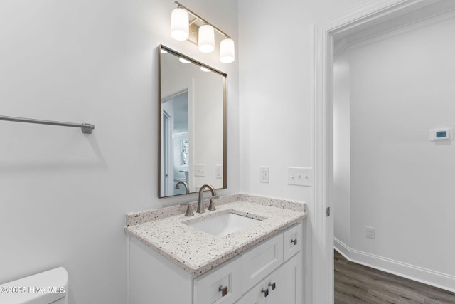 211 NE 78th St, Oak Island, NC 28465 - bathroom with vanity, toilet, wood finished floors, and baseboards