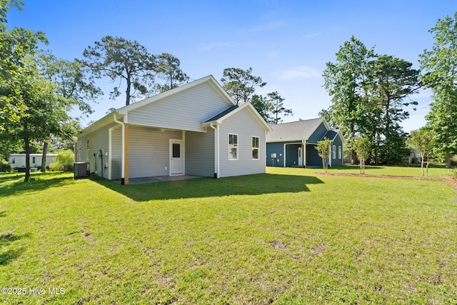 211 NE 78th St, Oak Island, NC 28465 - rear view of property with a lawn and central air condition unit