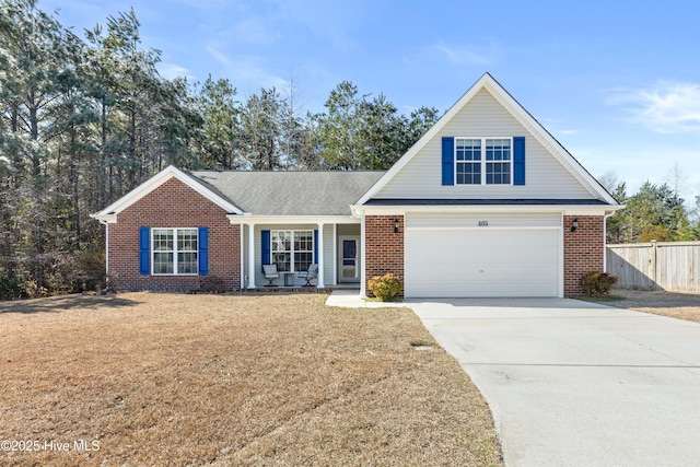 view of front of property featuring driveway, brick siding, an attached garage, fence, and a front yard