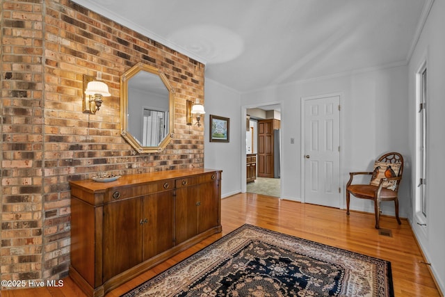 corridor featuring crown molding, baseboards, and wood finished floors