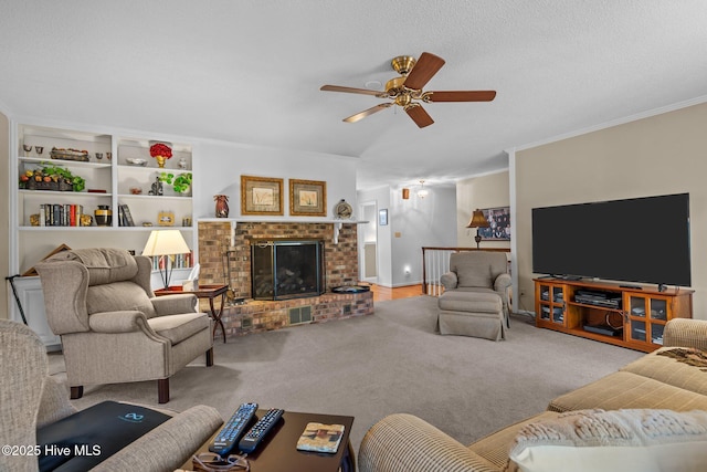 carpeted living area featuring ornamental molding, a fireplace, a textured ceiling, and ceiling fan