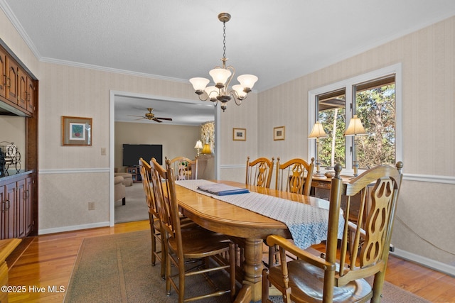 dining room with light wood-style floors, baseboards, an inviting chandelier, and wallpapered walls