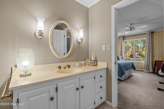 ensuite bathroom with ornamental molding, a ceiling fan, vanity, ensuite bath, and a textured ceiling