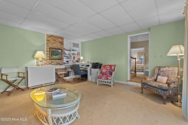 carpeted living area with a drop ceiling, visible vents, and baseboards