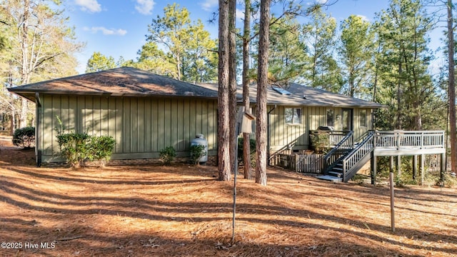 back of house featuring board and batten siding, stairway, and a wooden deck