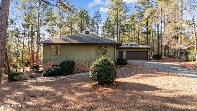 view of home's exterior featuring driveway, an attached garage, and brick siding