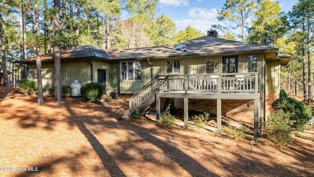 rear view of property with stairs, a shingled roof, a chimney, and a wooden deck