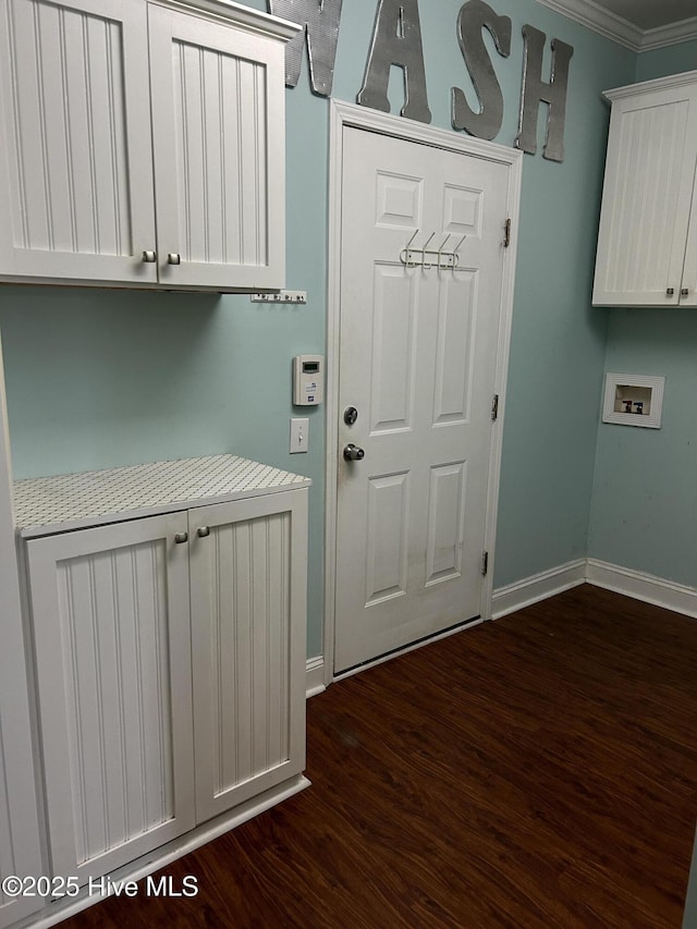 clothes washing area featuring cabinet space, baseboards, dark wood-style floors, hookup for a washing machine, and crown molding