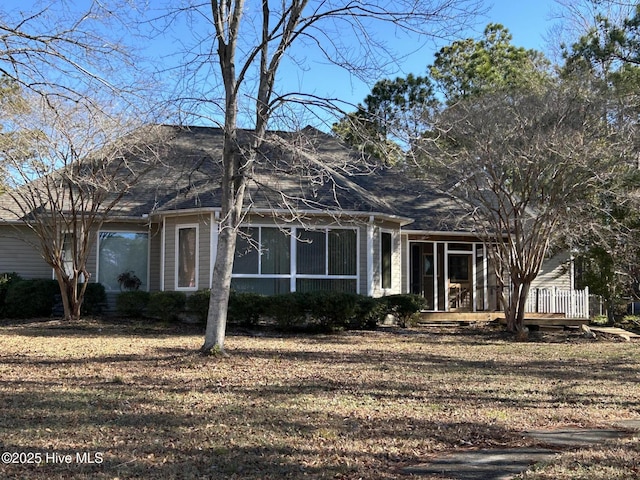 view of front of home with a sunroom and a front yard