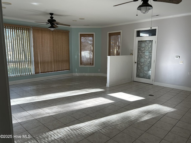 spare room featuring baseboards, ornamental molding, ceiling fan, and light tile patterned flooring