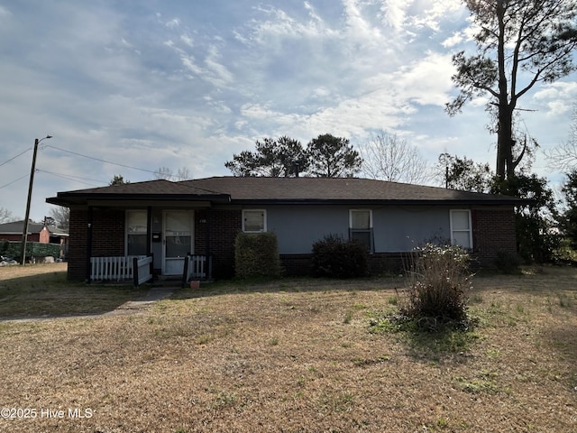 ranch-style home featuring brick siding, a porch, and a front yard