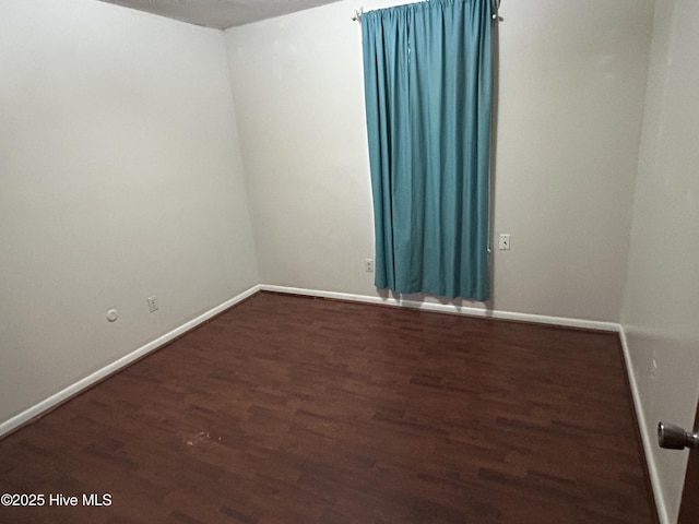 empty room featuring baseboards and wood finished floors