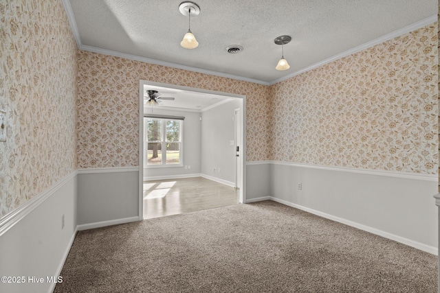 spare room featuring crown molding, carpet floors, and a textured ceiling