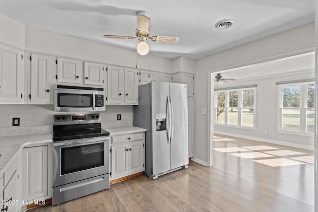 kitchen with ceiling fan, light hardwood / wood-style flooring, stainless steel appliances, and white cabinetry