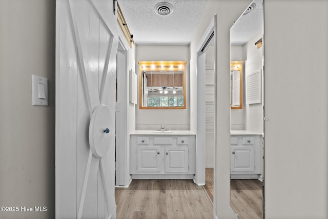 bathroom featuring a textured ceiling, vanity, and hardwood / wood-style floors