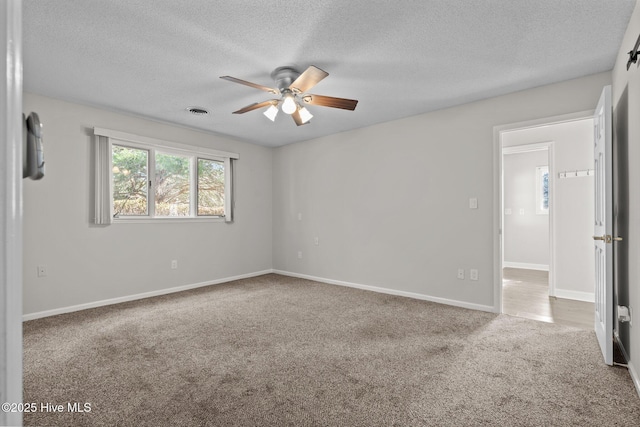 carpeted empty room featuring ceiling fan and a textured ceiling