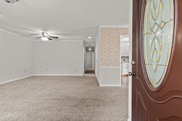 entrance foyer with crown molding, carpet flooring, and ceiling fan