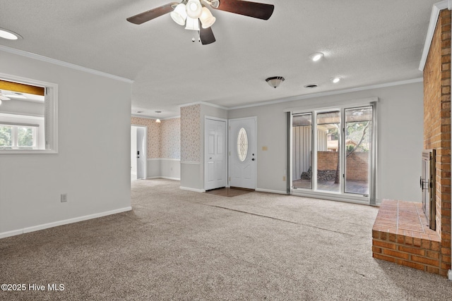 unfurnished living room featuring ceiling fan, ornamental molding, carpet, and a textured ceiling