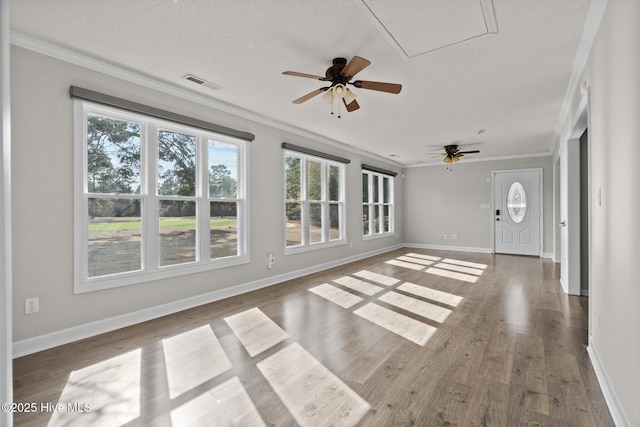 unfurnished living room featuring a textured ceiling, wood-type flooring, and ornamental molding