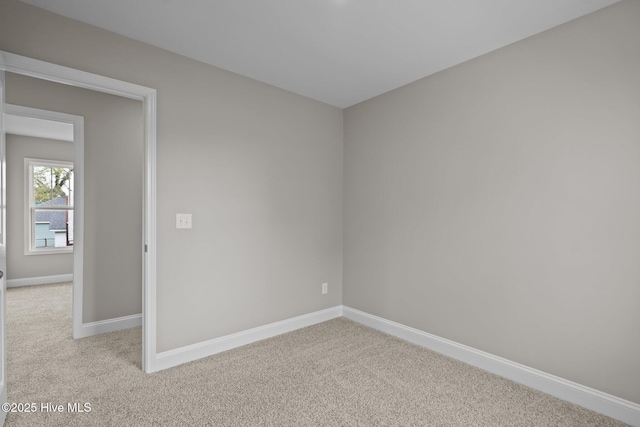 unfurnished room with carpet flooring and baseboards