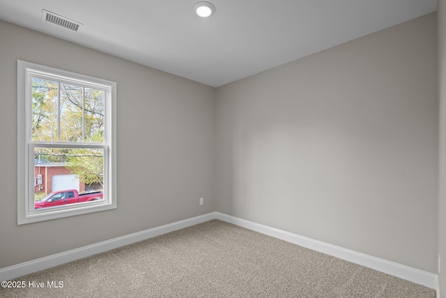 spare room with carpet floors, baseboards, and visible vents