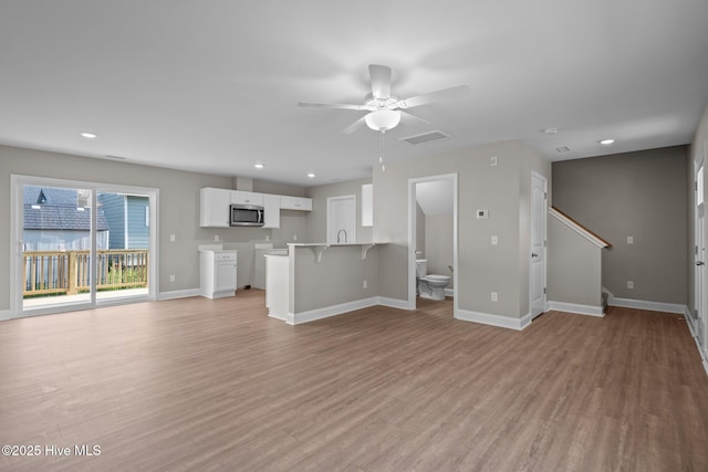 unfurnished living room featuring baseboards, a ceiling fan, light wood finished floors, and visible vents