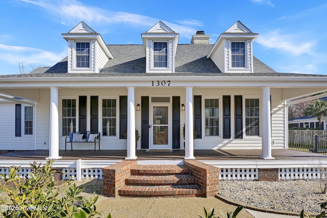 1307 Edgewater Club Rd, Wilmington, NC 28411 - view of front facade with covered porch, a shingled roof, fence, and a chimney