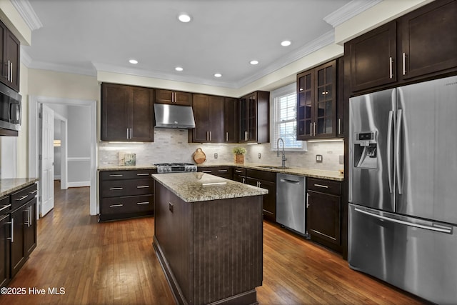 1307 Edgewater Club Rd, Wilmington, NC 28411 - kitchen featuring stainless steel appliances, under cabinet range hood, a sink, ornamental molding, and dark wood-style flooring