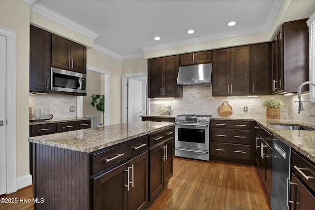 1307 Edgewater Club Rd, Wilmington, NC 28411 - kitchen featuring under cabinet range hood, stainless steel appliances, a sink, dark wood finished floors, and a kitchen island
