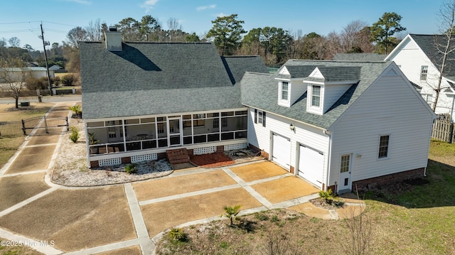1307 Edgewater Club Rd, Wilmington, NC 28411 - back of property with a sunroom, a shingled roof, a chimney, and driveway