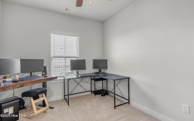 carpeted home office featuring ceiling fan