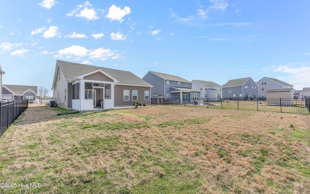 rear view of house featuring a yard, a sunroom, and central air condition unit